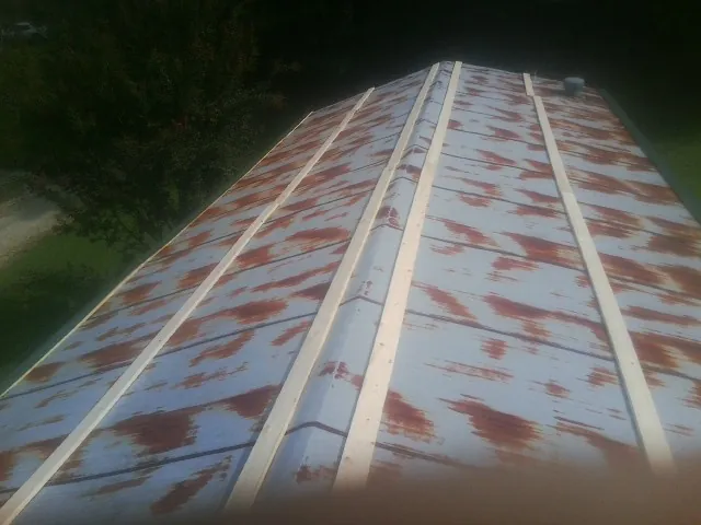 Rusted metal roof panels with new wood purlins before replacement — Storm Damage Roof Repair in Clinton Corners by Roofing Brothers