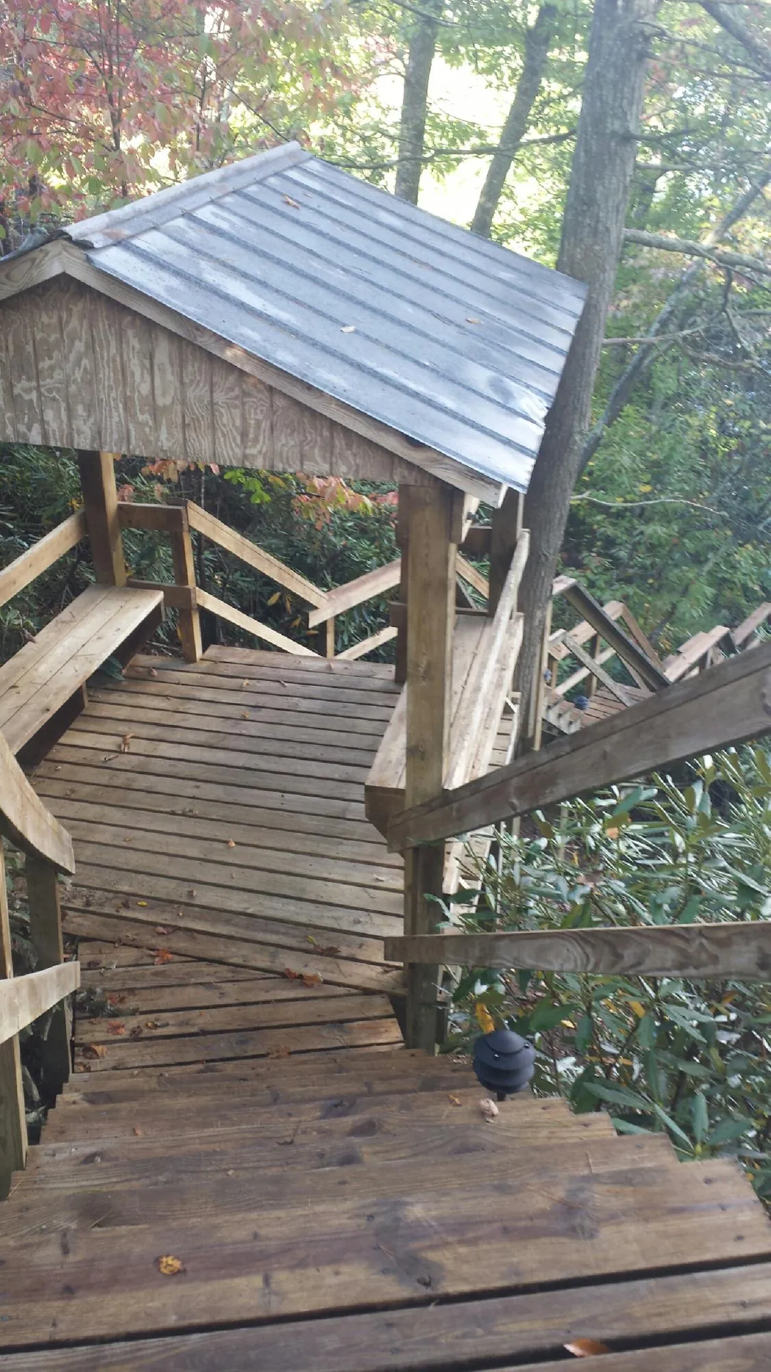 Metal roofed shelter over wooden steps on a wooded walkway — Skylight Repair & Installation work by our crew in Clinton Corners